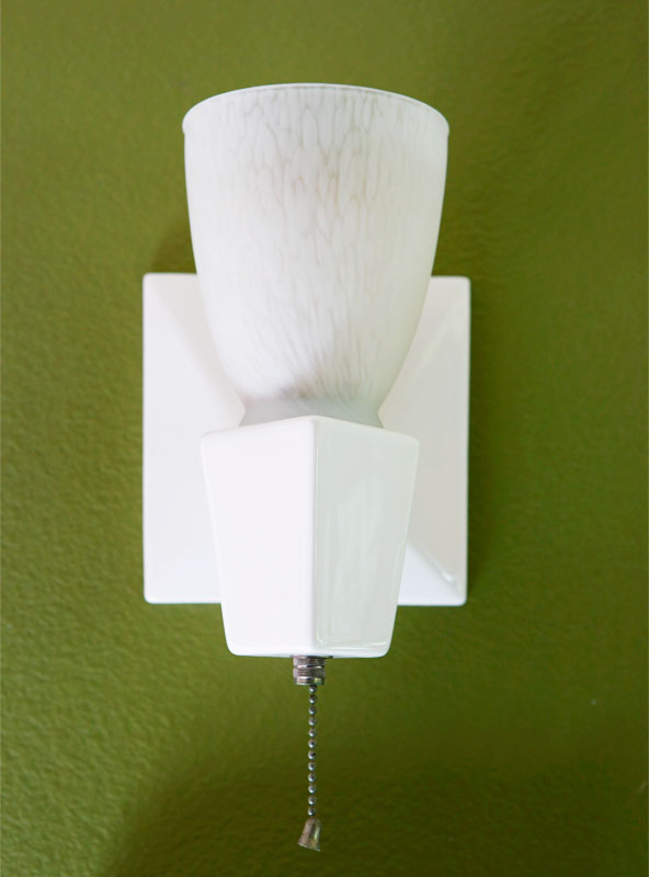 A period-style porcelain sink adds a fresh contrast to the rich walls.