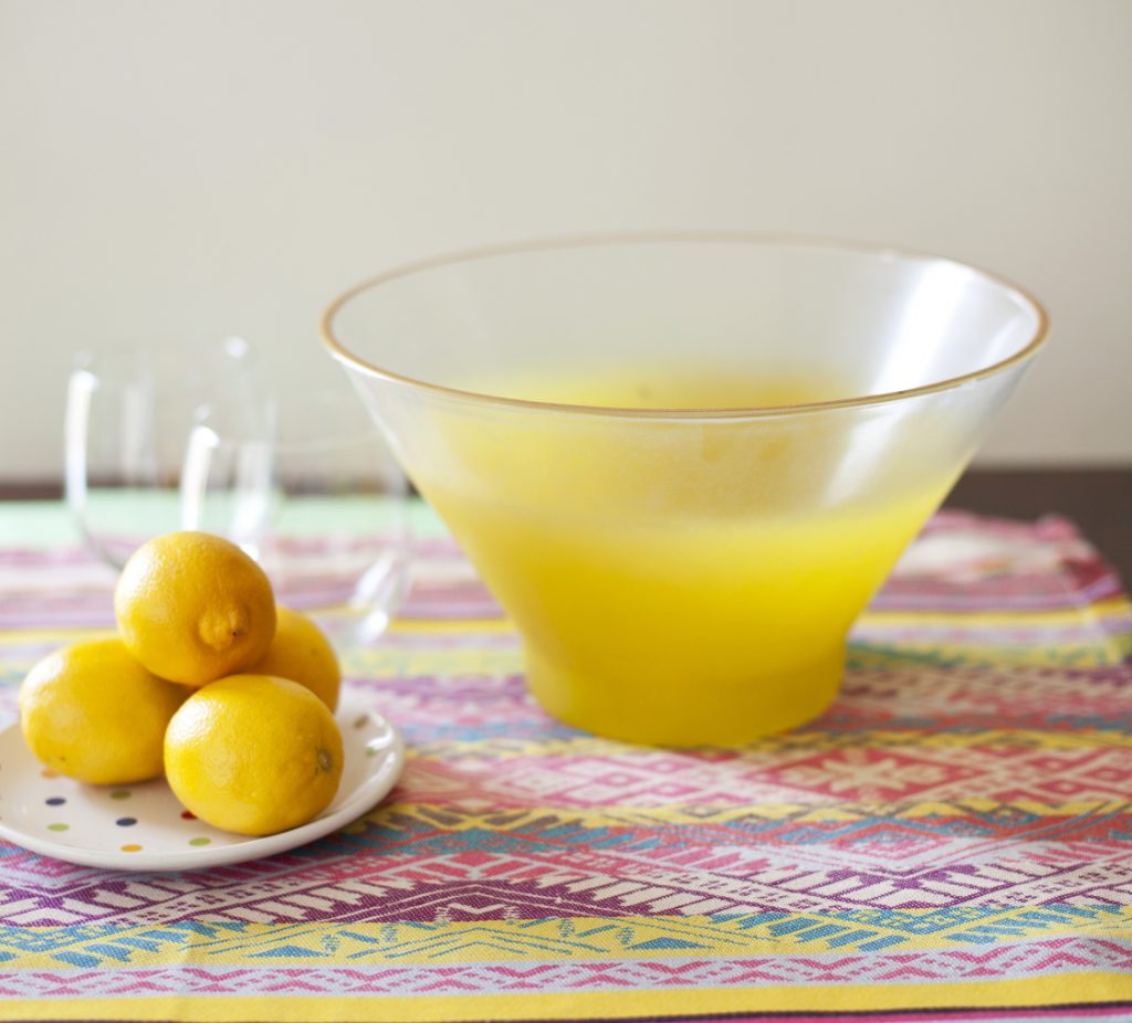 Blendo style bowl placed on a table next to a plate of lemons.