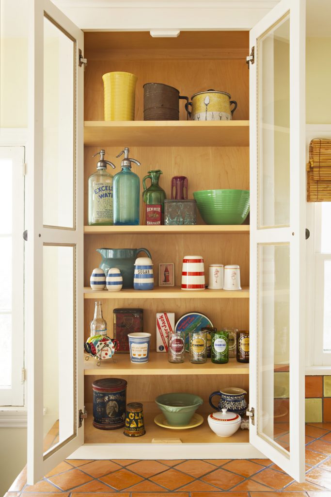 Open glass cabinets filled with antique pottery and dishes