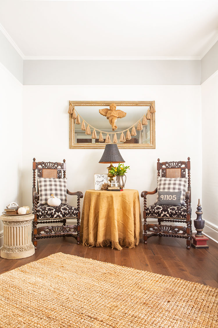 Jute rug leading to two as sitting area with two antique wooden chairs. 