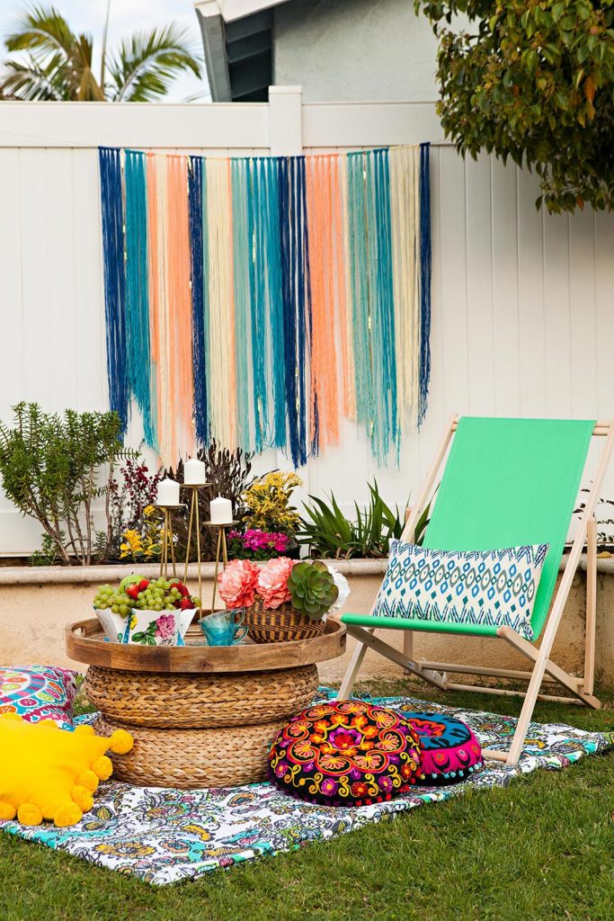 DIY yarn art garland in a summery boho backyard setting