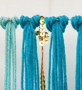 a closeup of the DIY yarn art garland looping technique