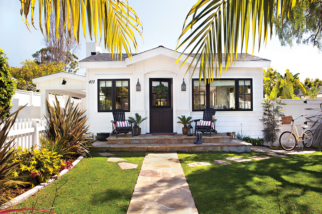 Patriotic cottage exterior with white paint and black trim.