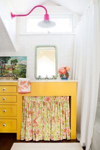 yellow bathroom sink vanity with a floral curtain concealing the storage area