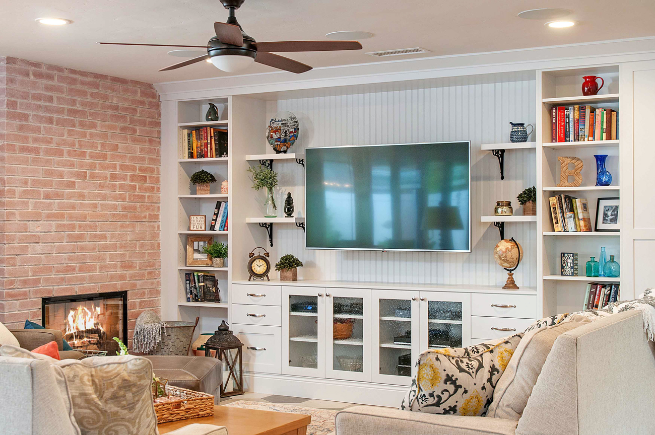 Built in white cabinets and entertainment center complimented by a floor-to-cieiling brick fireplace. 