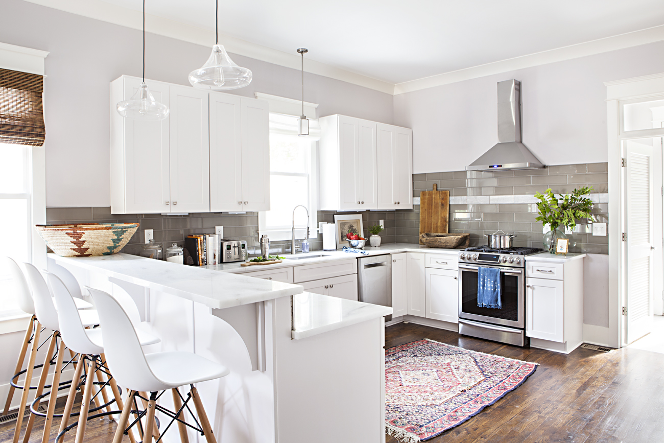 Bright, white open concept kitchen with vintage Persian rug. 