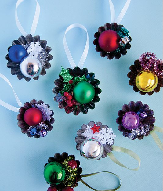 How To Do It: 1. Using a mini tart tin as the base, arrange the small decorative embellishments on top in your desired composition. 2. You can use a pencil to twist the pipe cleaners and formable garlands into a spiral shape.