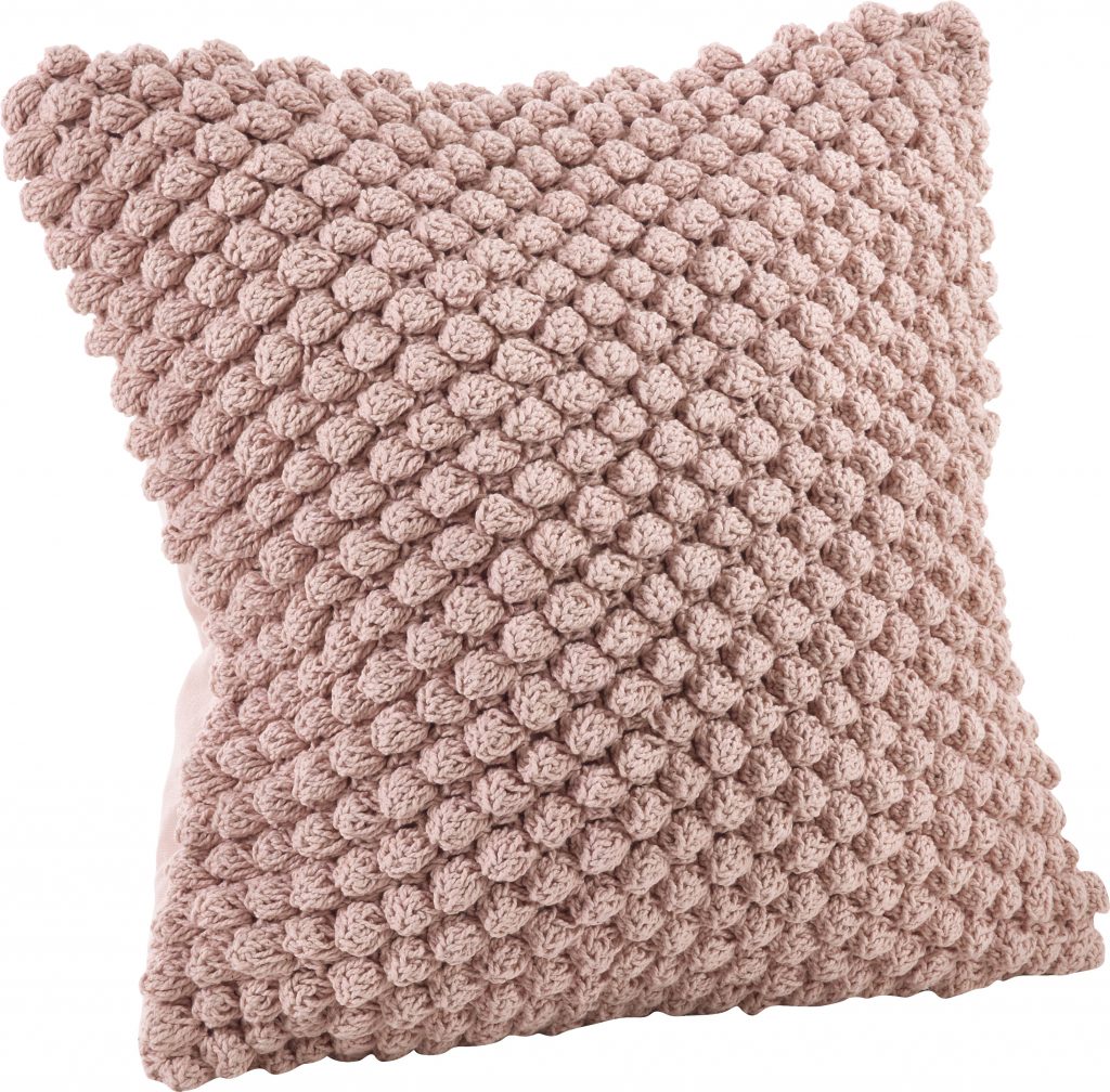 Light pink pillow with crocheted pompom accents.