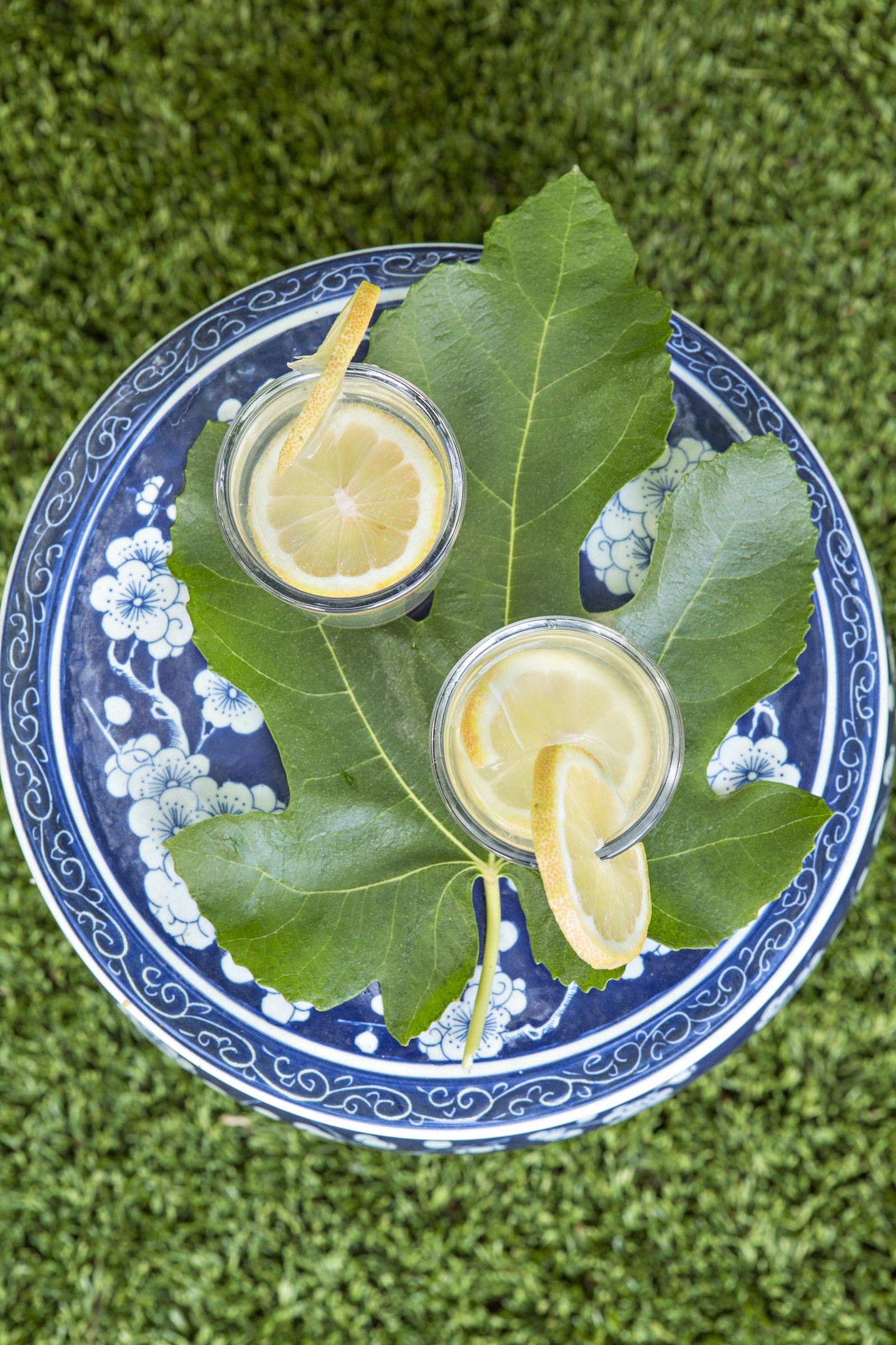 fresh lemonade on a big fig leaf and blue ceramic garden stool