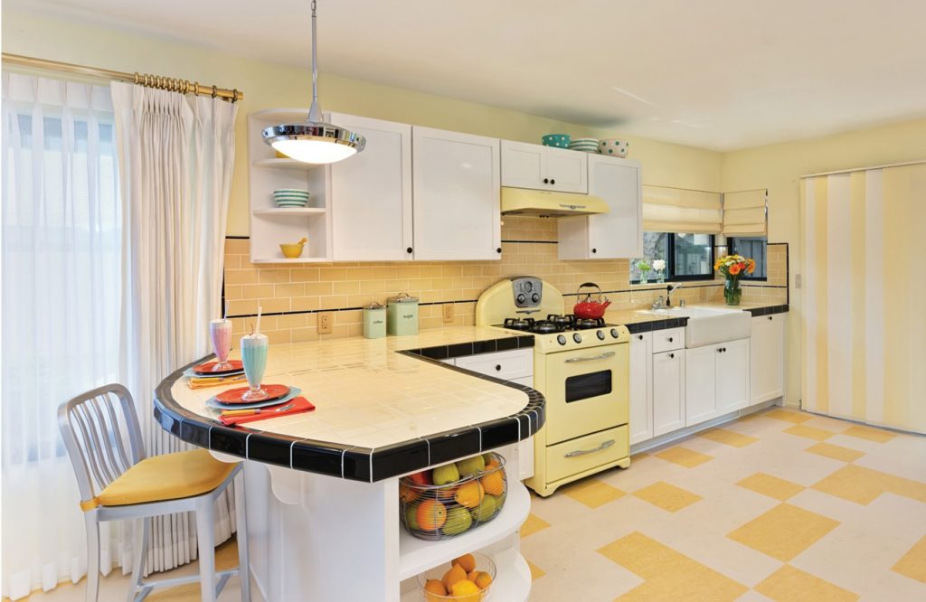 Retro kitchen with yellow tile and stove and black accents.