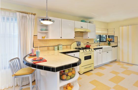 Retro kitchen with yellow tile and stove and black accents.