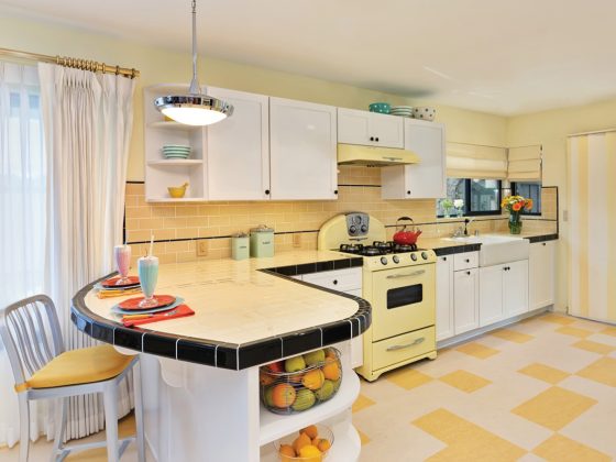 Retro kitchen with yellow tile and stove and black accents.