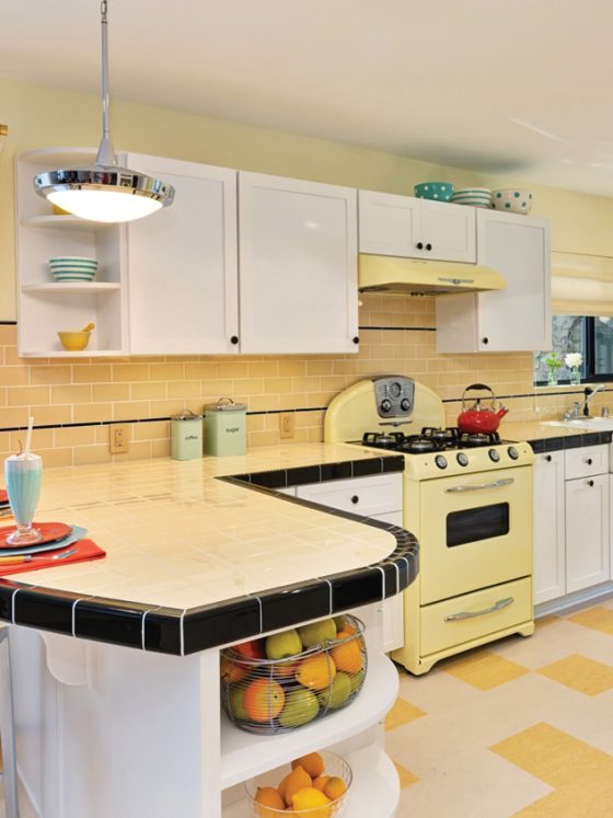 Retro kitchen with yellow tile and stove and black accents.
