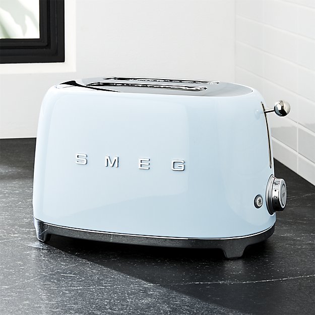 Smeg toaster in light blue on a black granite counter top in front of white subway tile backsplash