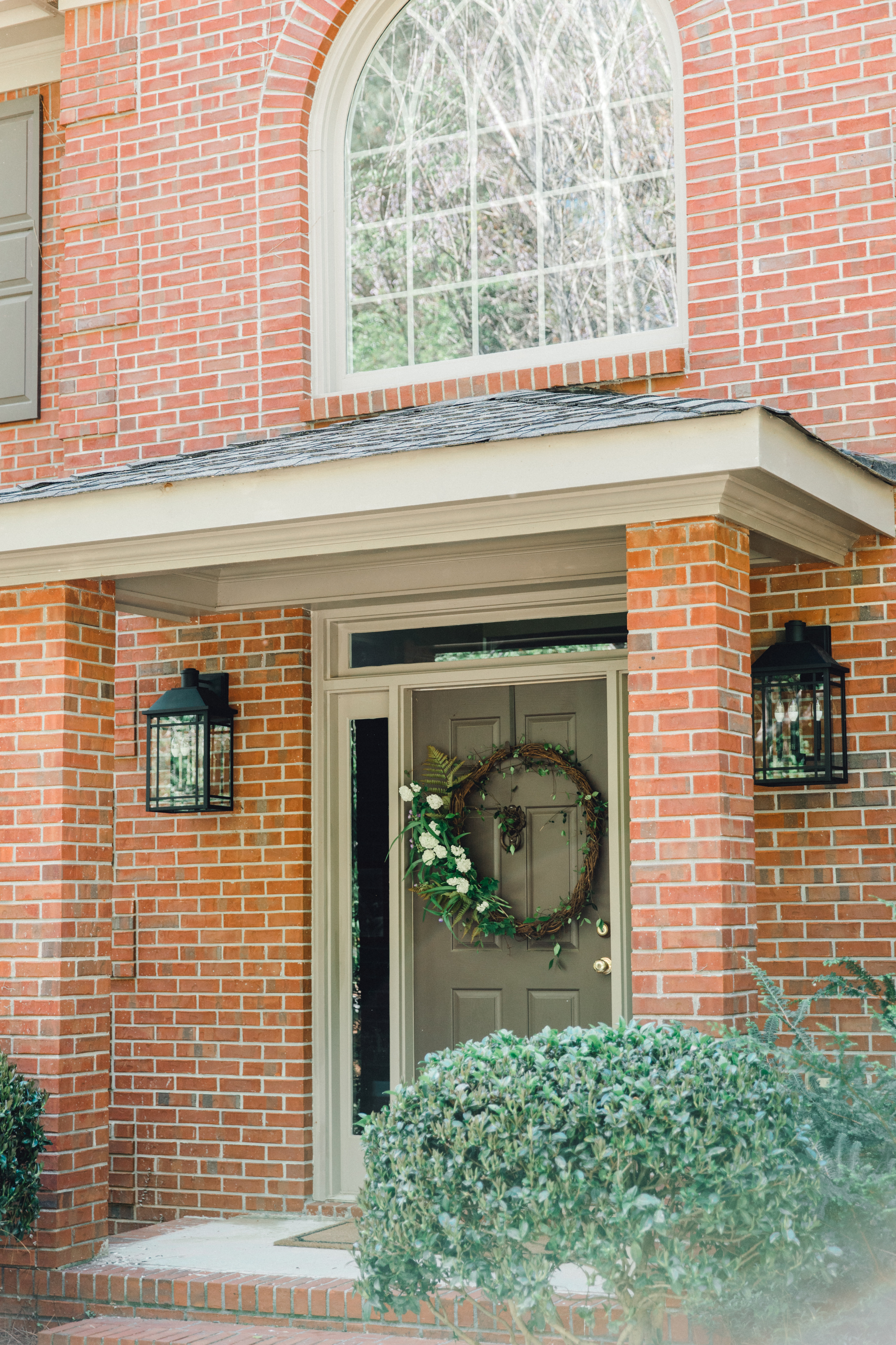 Braden Lankford Lanterns Hanging on the front porch of a brick home