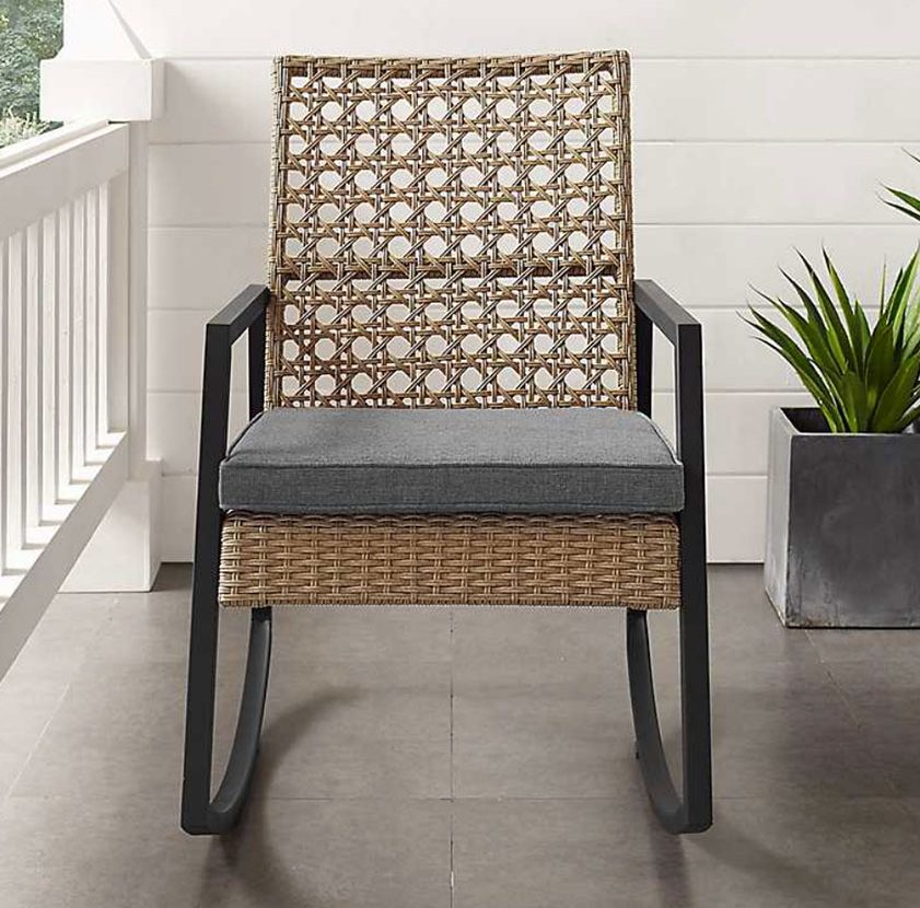 cane back outdoor rocker on a front cottage style porch which are summer bbq necessities for seating