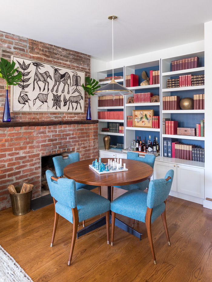 Dining room with brick and white accents and collected travel decor