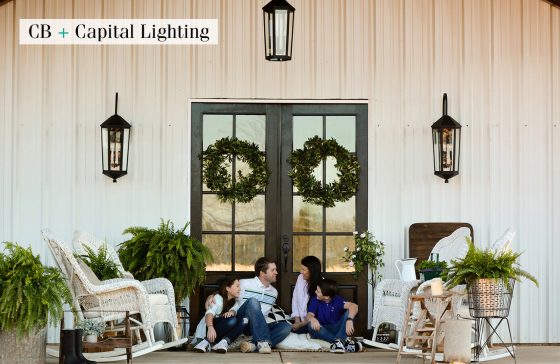 Porch Light Fixtures and White Farmhouse Home with a family sitting on the front porch.