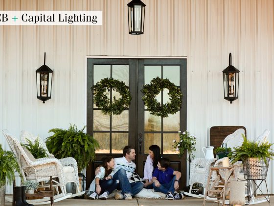 Porch Light Fixtures and White Farmhouse Home with a family sitting on the front porch.