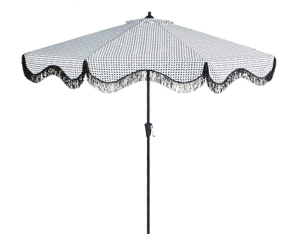 summer bbq necessities: patio umbrella with scalloped fringe trim. The pattern is white with small irregular black dots. 