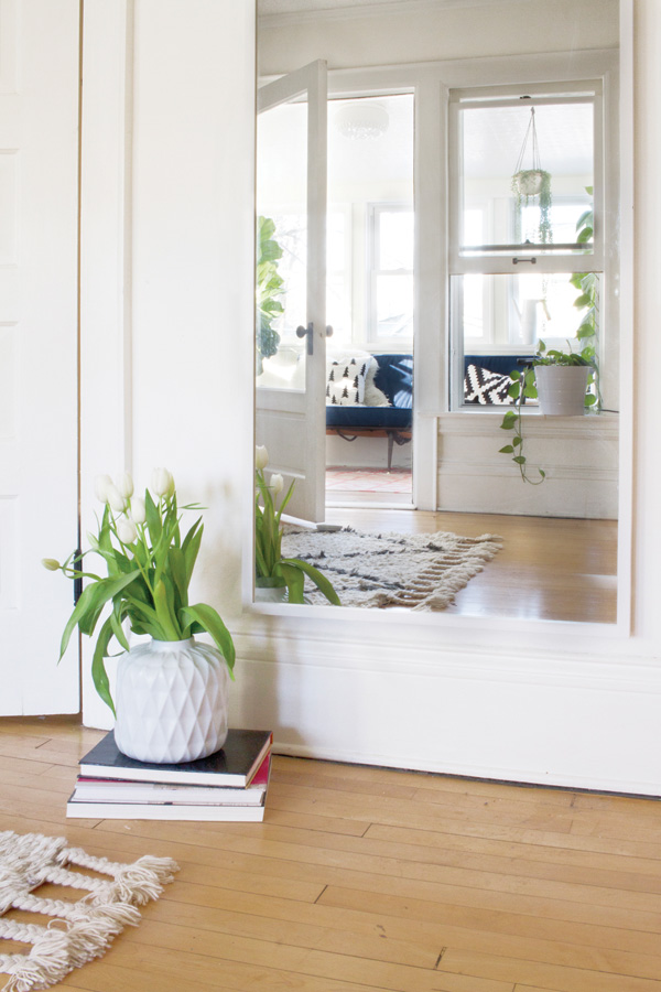 Sleek design mixed with rustic charm. A stack of books acts as a table for the flower vase and tulips add height to the space.