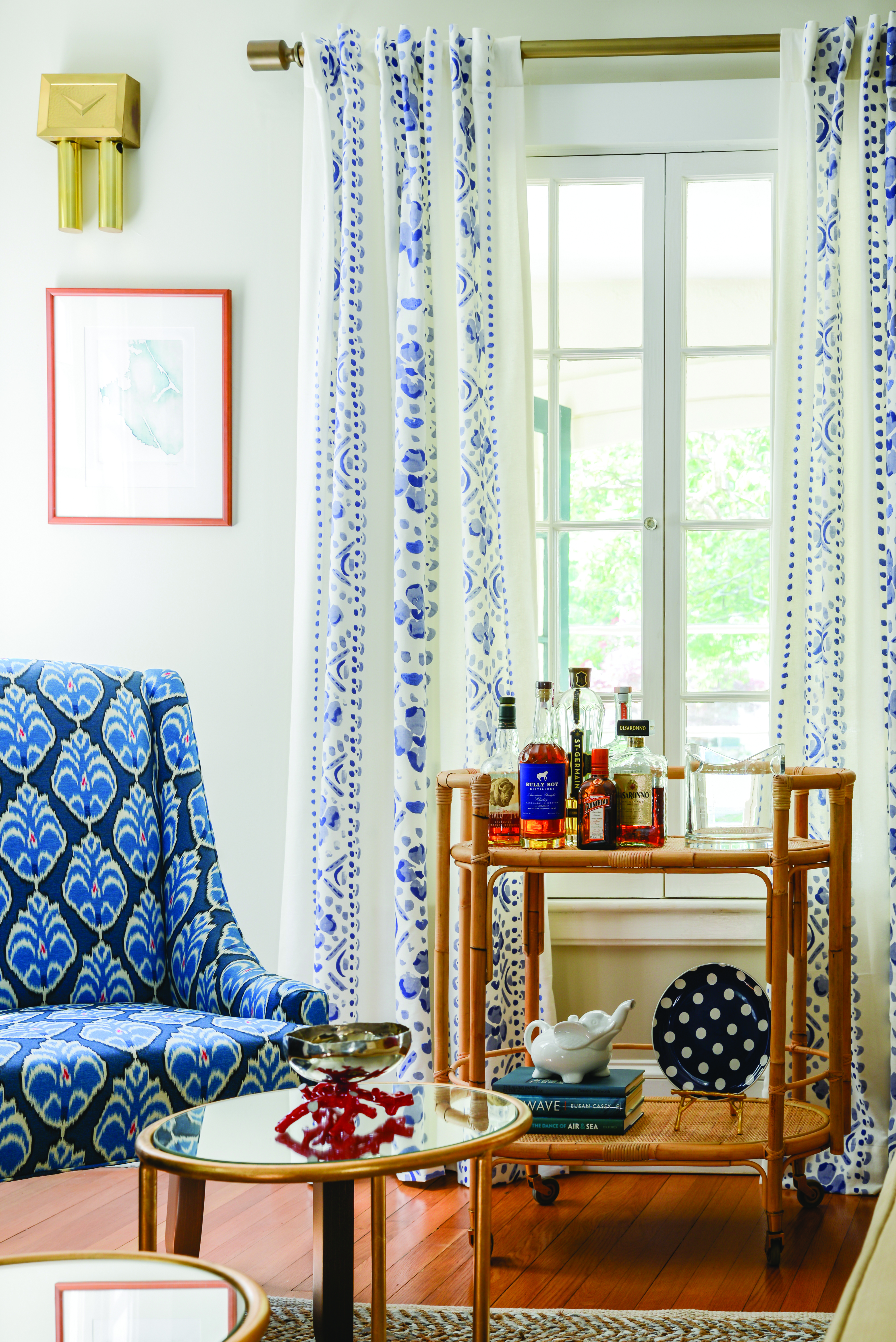 This blue patterned accent chair, shown here, and pops of color create a cohesive palette in this living room.