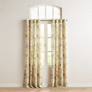 Light and bright floral curtain panels displayed near a large window on a blank wall.