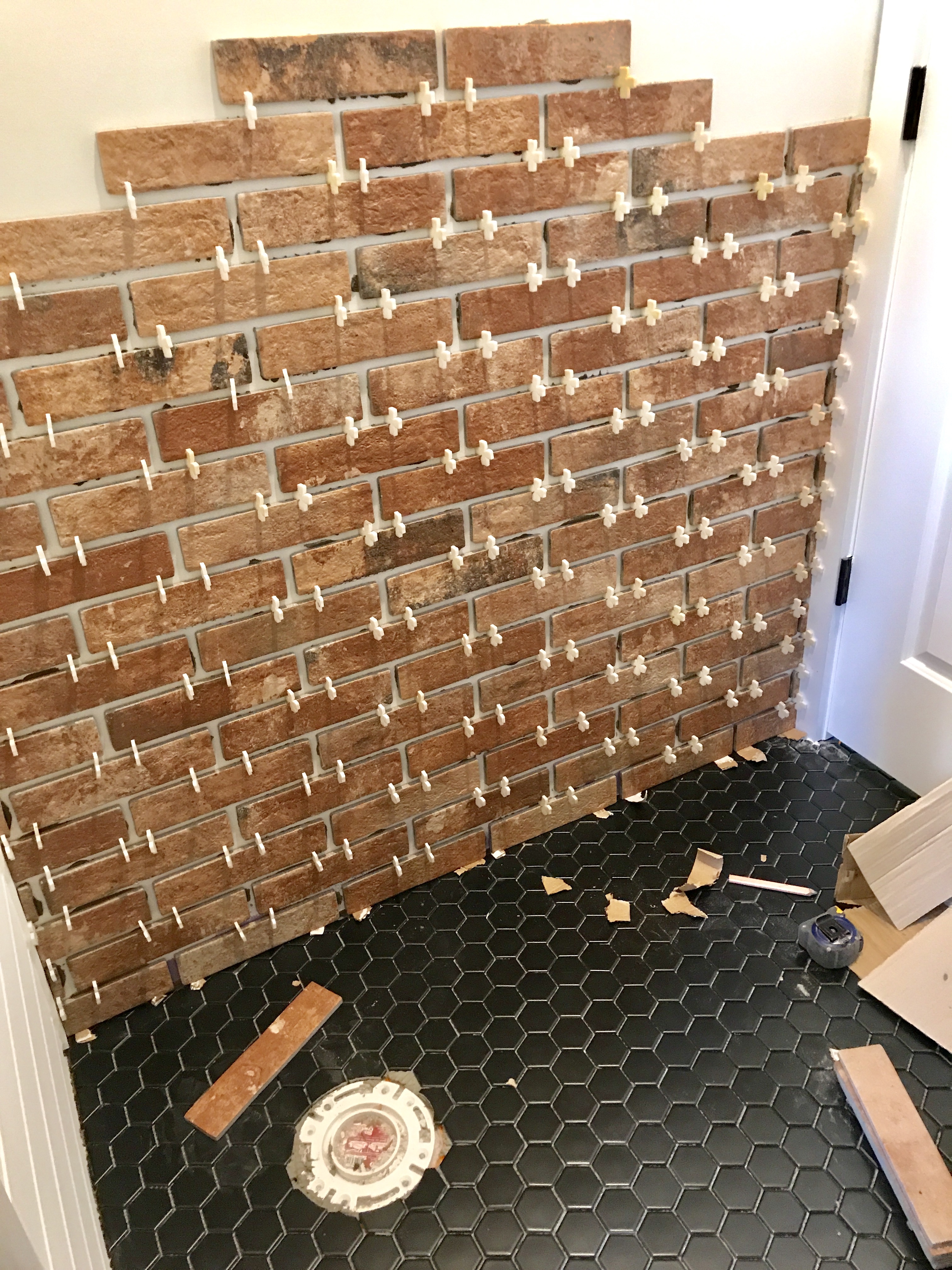 A brick accent wall was added to the master bath to give the room's farmhouse look an industrial flair.