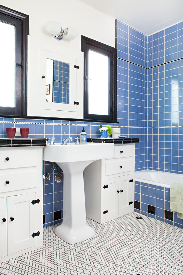 Restored Spanish bungalow bathroom with blue tile and black and white accents.