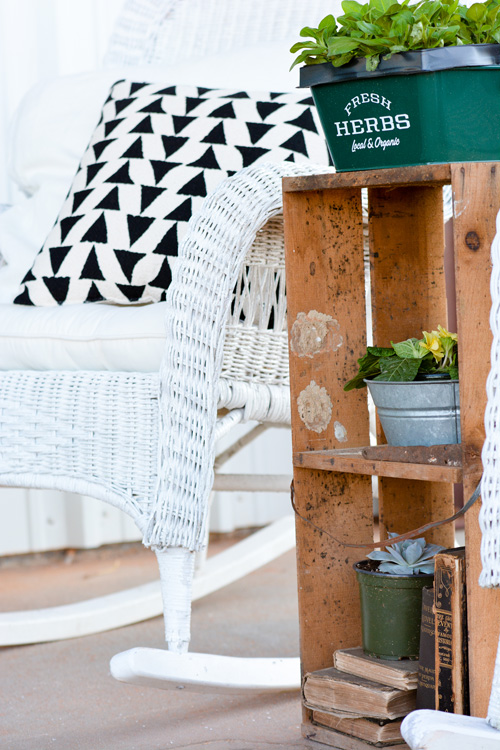 An old crate becomes the perfect stand-in for a plant stand adding Katie’s signature vintage creativity to the porch. 