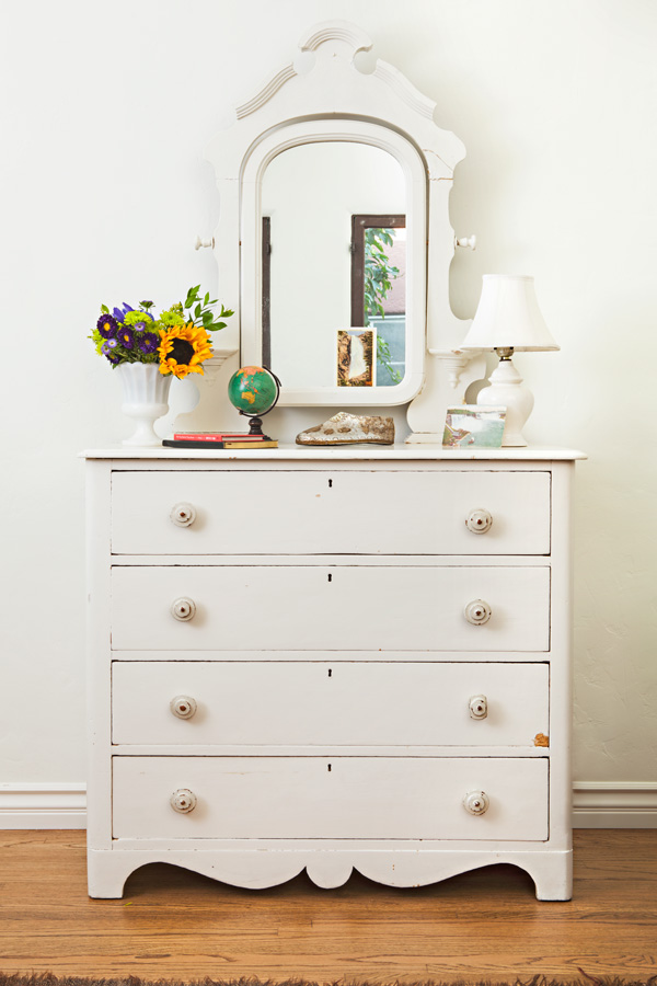 vintage dresser with chippy paint and an ornate attached mirror