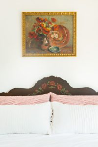 vintage paiting above an antique bed with painted detail
