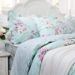 a baby blue and pink hydrangea duvet set on a white shabby cottage bed. Summer linen style.
