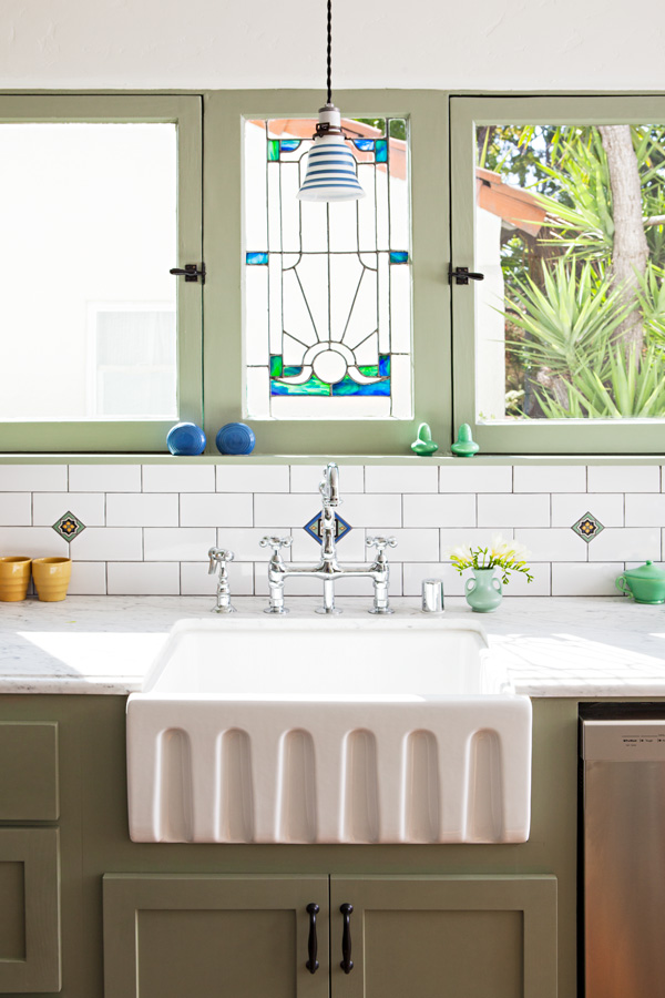 spanish bungalow kitchen after with stained glass and a farmhouse sink. 