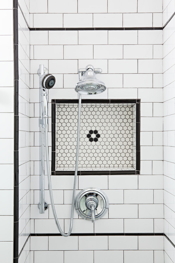 White hex tile with subway tile combo and black detailing in this renovated shower