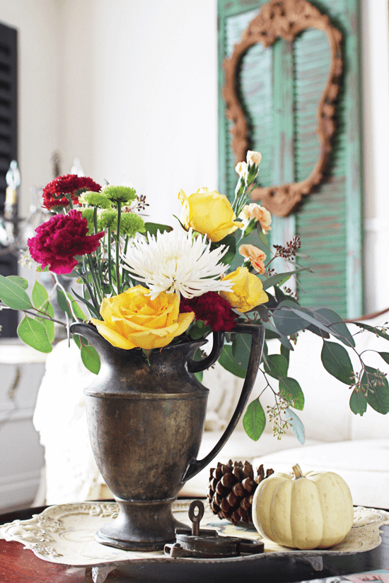 This vintage flower arrangement with a pumpkin accent make for a beautiful side table display.