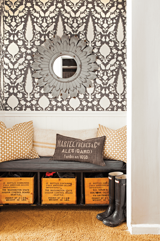 Coat closet turned sitting area outfitted with a custom bench, extra kitchen wallpaper and a mirror.