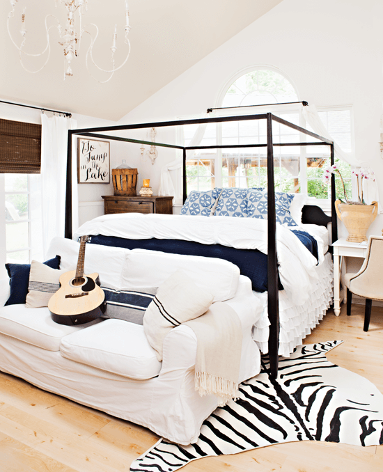 Airy master bedroom with high ceilings and hues of white, blue and black.