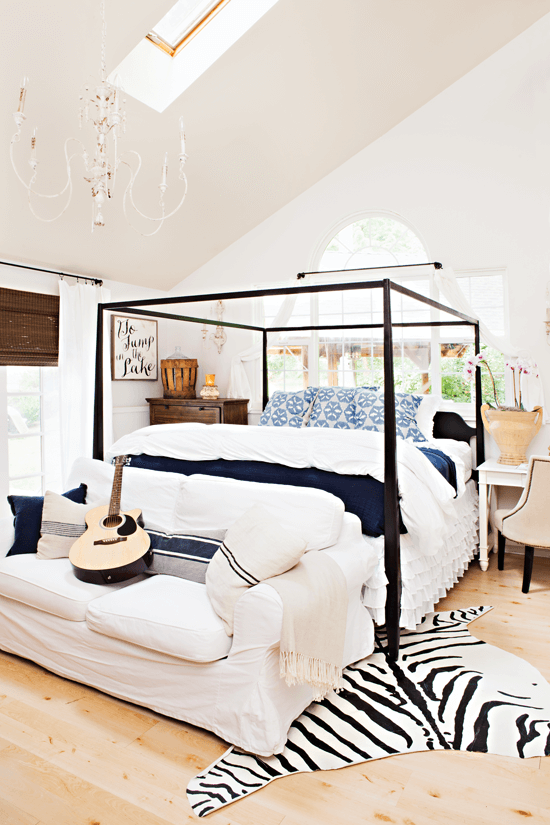 Airy master bedroom with high ceilings and hues of white, blue and black.