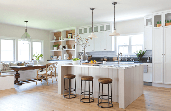 This sleek, contemporary kitchen features white cabinetry, high-end stainless steel appliances, a panel-covered refrigerator and freezer. A distressed oak range hood and accent kitchen island was added for a twist on the traditional look.