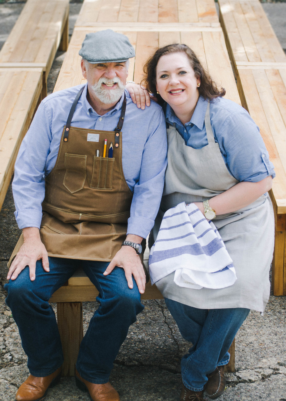 Sarah (right) pictured with her father, Lee (left), who is in charge of building the tables. He collects real cedar from a local lumbar yard and starts shaping tables that are customized by size and stain. 