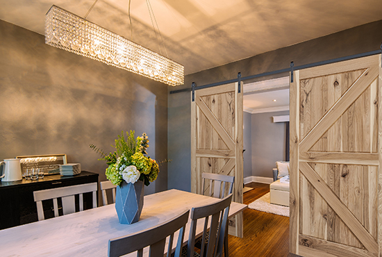 Woodgrain sliding barn doors, shown here in a dining room and living area.