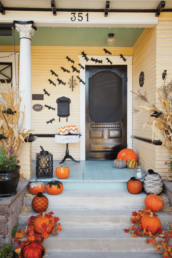 Cut bat shapes from black cardstock; then fold them in the center for a more three-dimensional look. Affix a flock of them to the wall, arranging them in a swooping flight pattern.