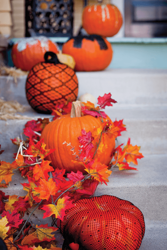 Draw the eye up to your door with a boost of curb appeal by lining your porch steps with a variety of pumpkins.