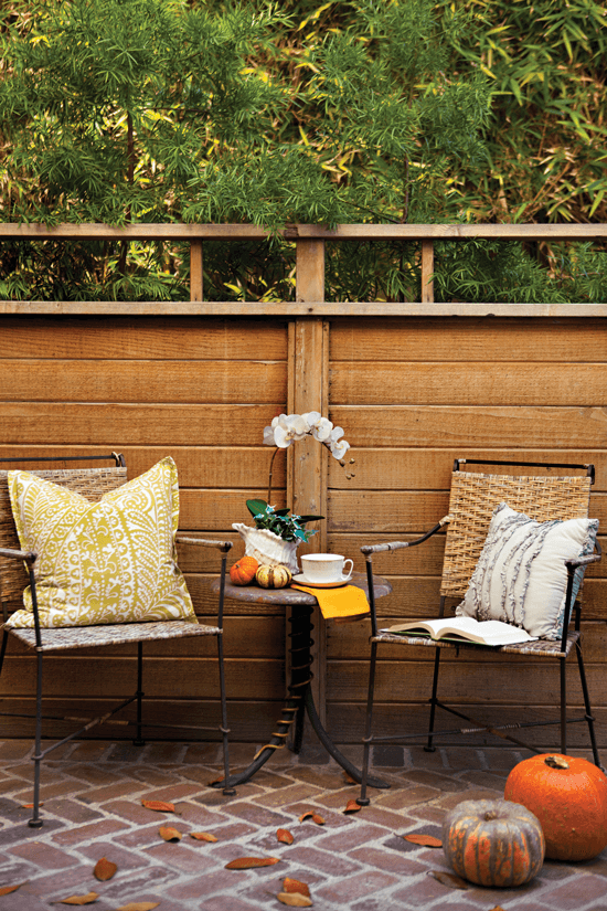 On a serene patio off the office, a bistro set among natural textures like brick and wood makes for a cozy nook.