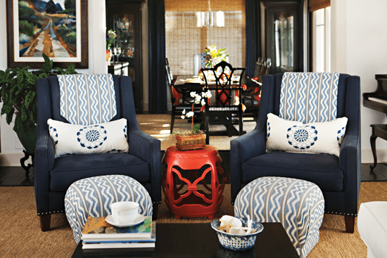 An inspiration piece for the home’s color scheme, this orange side table is joined by a pair of navy armchairs.
