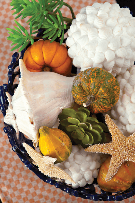 Simple, nature-inspired items like starfish and greenery mix well in a decorative bowl with seasonal touches