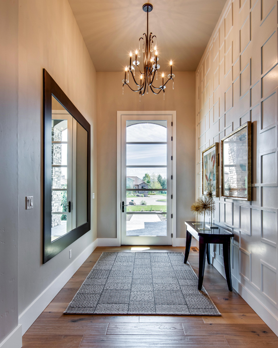 In this hallway, the wainscoting plays with the shapes of the framed art and mirrors, acting as another repeating set of rectangular art.