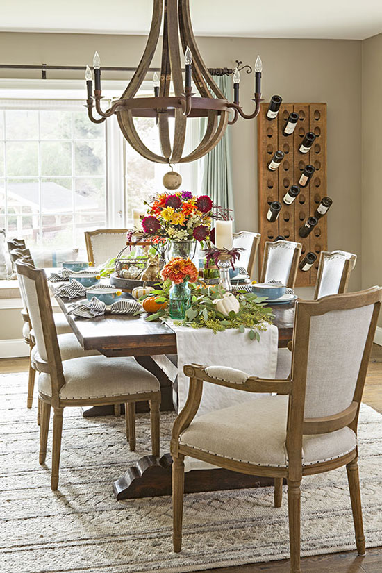 A colorful flower centerpiece sprinkled with greenery and a muted palette come together to create the perfect fall Thanksgiving table.