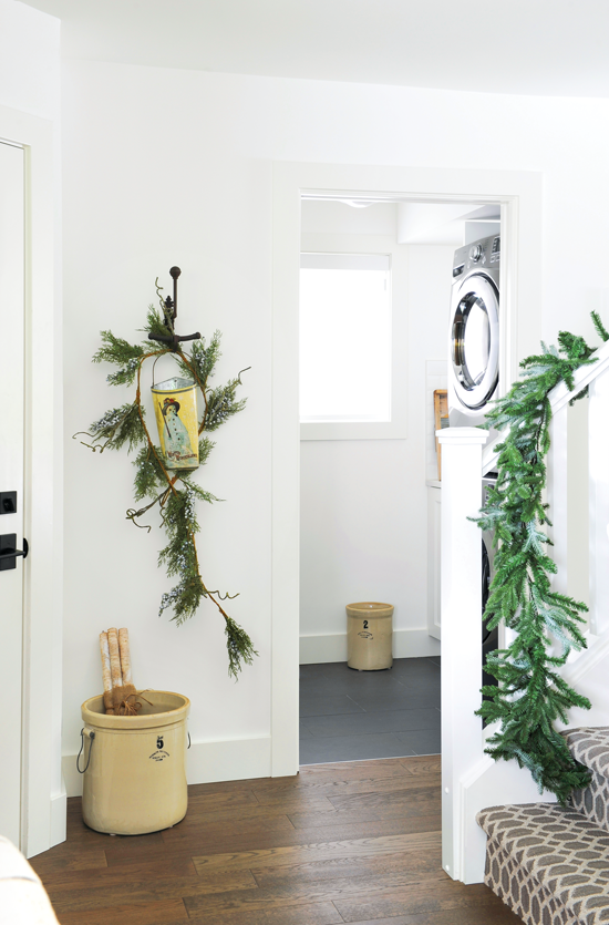 Light and bright home entryway decorated with greenery for the holiday season. // Cottages & Bungalows